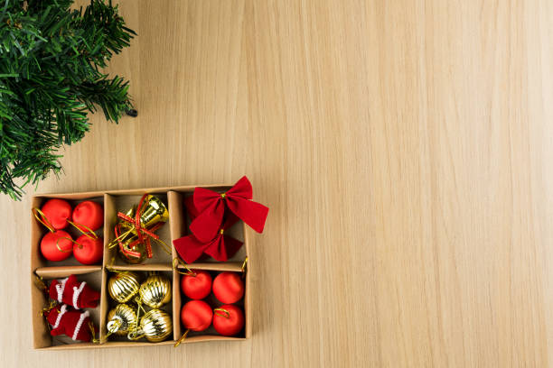 istock Table with light wood texture with small Christmas tree and box with the hanging ornaments 1347546665