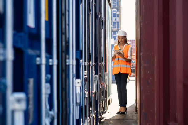 istock Engineers are overseeing the transportation of cargo with containers inside the warehouse. Container in export and import business and logistics. 1347547966