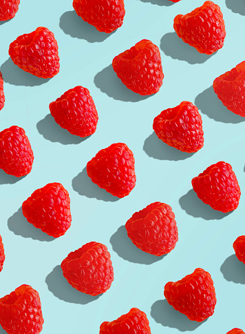 Fresh raspberries on a pastel colored background