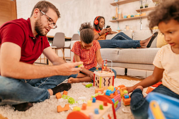 istock Father playing with daughters on floor in living room 1347550647