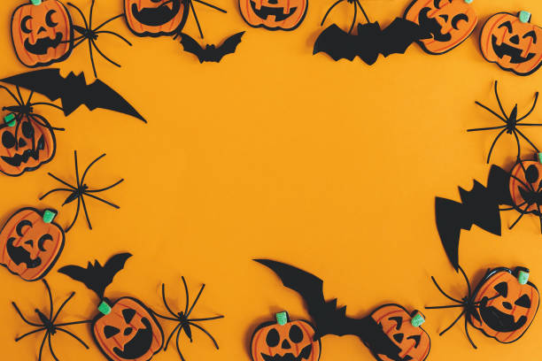 istock Modern pumpkins jack o lantern, spiders, bats frame flat lay on orange background with space for text. Season's greeting card. Happy Halloween. Halloween decorations on yellow paper 1347551266
