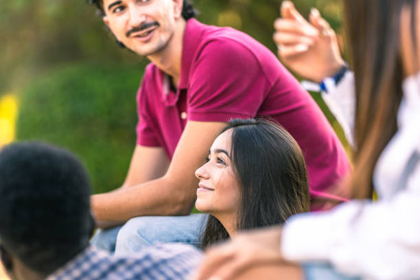 istock Woman smiling while sitting on a bench with diverese people in a park 1347551380