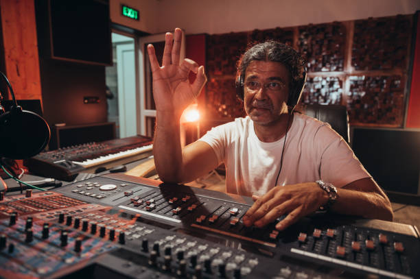 istock Senior hispanic music producer working on a mixing soundboard while in his studio 1347553263