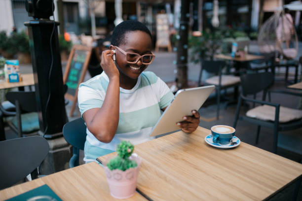 istock Happy African American woman using a digital tablet computer in a coffee shop 1347553363