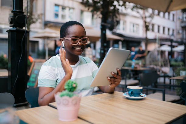 istock Happy African American woman using a digital tablet computer in a coffee shop 1347553380