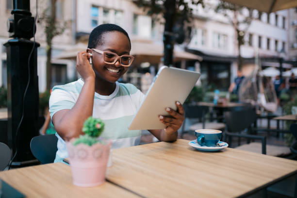 istock Happy African American woman using a digital tablet computer in a coffee shop 1347553389