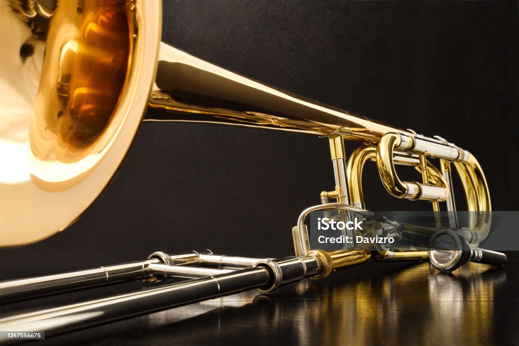 Trombone with transposer on a black table front view Trombone with transposer mounted on a white table. Front view. Horizontal composition. Trombone Stock Photo