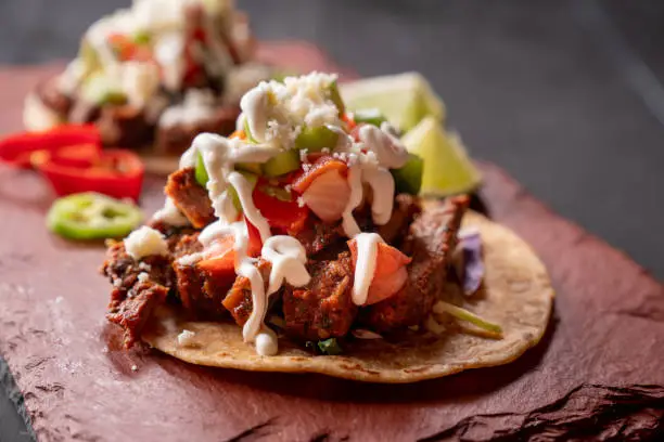 Beef Carne Asada Mexican Style Street Food Tacos with Marinated Steak, Cilantro, Onion, Cotija Cheese and Sour Cream