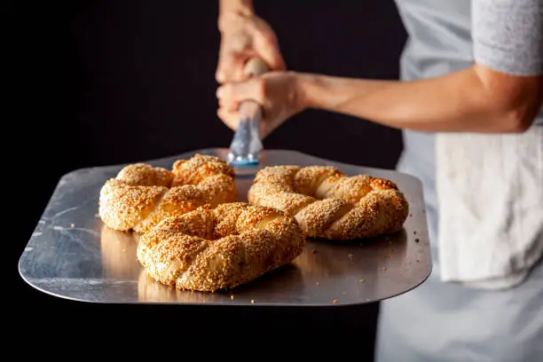 Photo of delicious Turkish bagel with sesame seeds known as susamli simit.