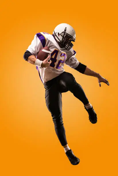 Photo of american football player in action. High jump of American football player