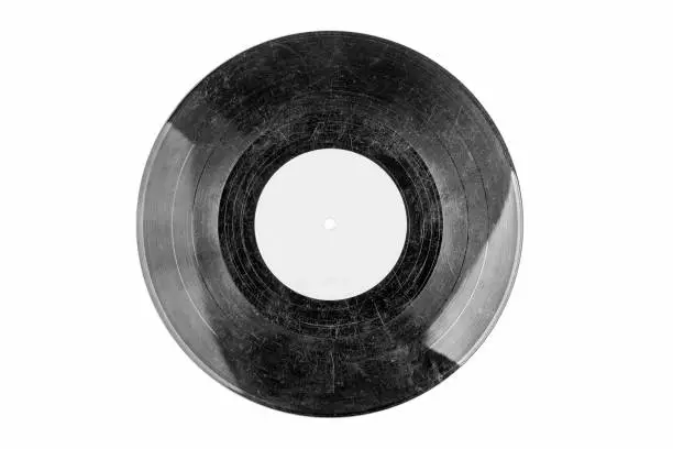 Photo of Old fashioned damaged scratched vinyl record, black and white hdr, object isolated on white background, cut out, empty blank label. Classic vintage retro vinyl disc with many deep scratches, top view