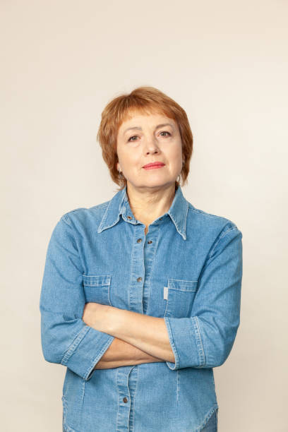 Close up studio portrait of attractive 60 year old woman with short red hair stock photo