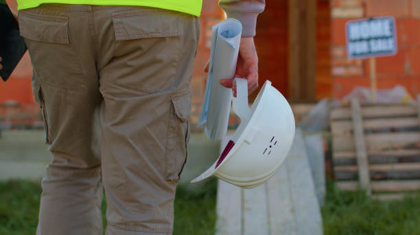istock Real estate foreman designer building project architect with helmet walking to construction site 1347565685