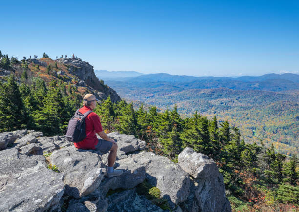 istock Hiker sitting on a cliff edge enjoying scenic view. 1347568376