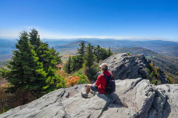 istock Hiker sitting on a cliff edge enjoying scenic view. 1347568381