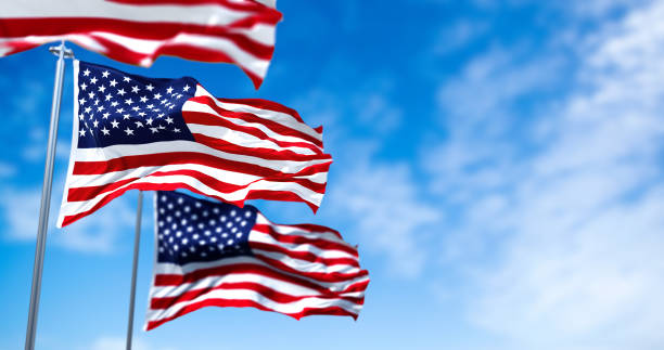 Three flags of the United States of America waving in the wind stock photo