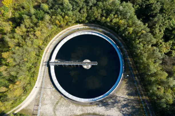 Aerial view of a clarifier in wastewater treatment plant in a forest environment.