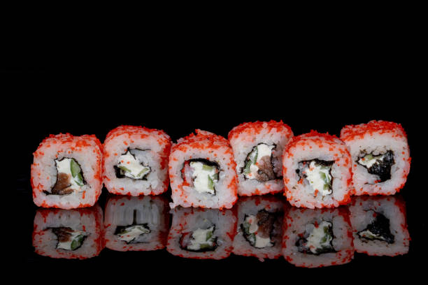 istock Philadelphia roll with salmon, cheese and cucumber on a black background with reflection. Sushi Philadelphia 1347573630