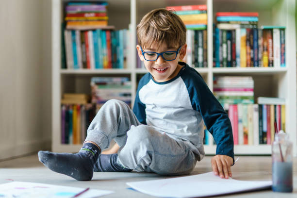 vista frontal de un niño caucásico de cuatro años jugando en el suelo de su casa - 4 5 years fotografías e imágenes de stock