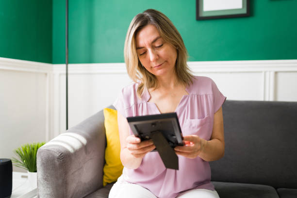 istock Senior woman holding a photo frame 1347578953