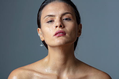 Portrait of young woman with wet face.