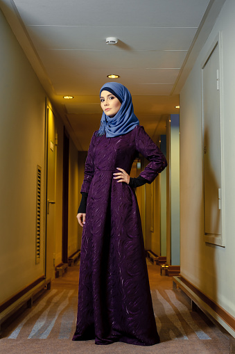 joven musulmana con ropa islámica de moda, de pie en el pasillo del hotel photo