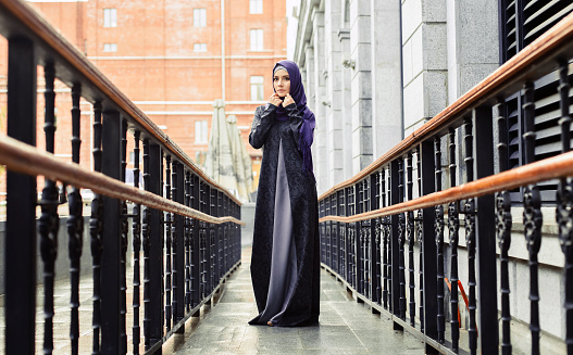 young Muslim woman in the modern Muslim clothing on the background of European architecture, Russia