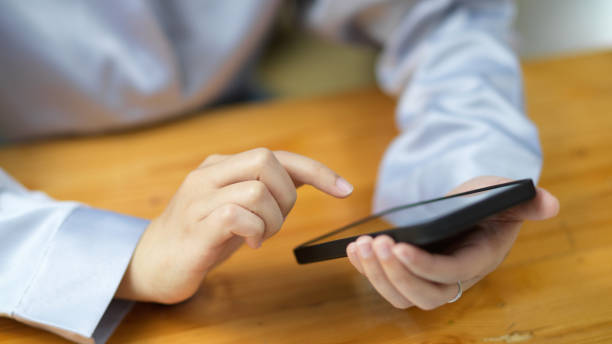 istock Female hands tapping on smartphone screen. female using smart mobile phone 1347591805