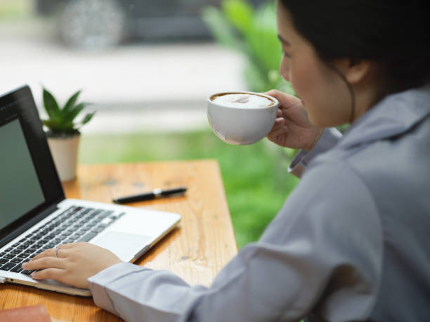 istock Young businesswoman drinking and sipping coffee while working on her laptop computer 1347591854