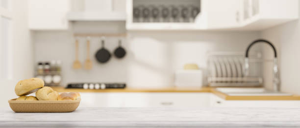 istock White marble counter top, kitchen island with basket bread and space for montage over modern kitchen room 1347591963