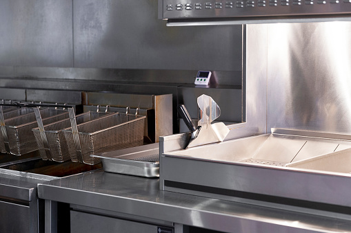 Stainless steel commercial kitchen with fries scoop & cooking timer.