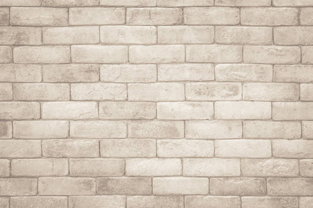 istock Cream and white brick wall texture background. Brickwork and stonework flooring interior rock old pattern clean concrete grid uneven bricks design stack. Background of old vintage brick wall 1347593696