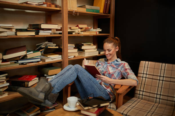 istock Cheerful female student enjoying book reading in library 1347593982