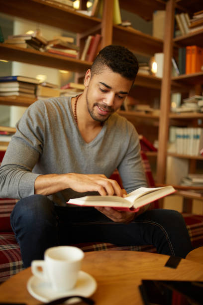 istock Smiling African American student enjoying book reading in library 1347594017