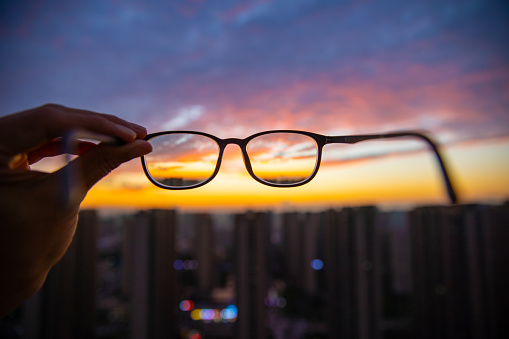 Looking through eyeglasses to city sunset