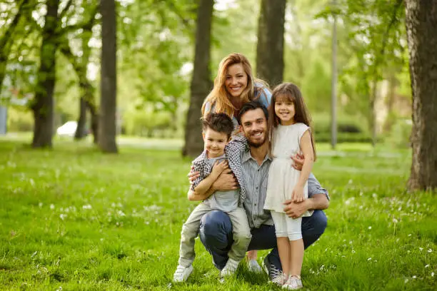 Cheerful parents and small kids enjoying time in nature