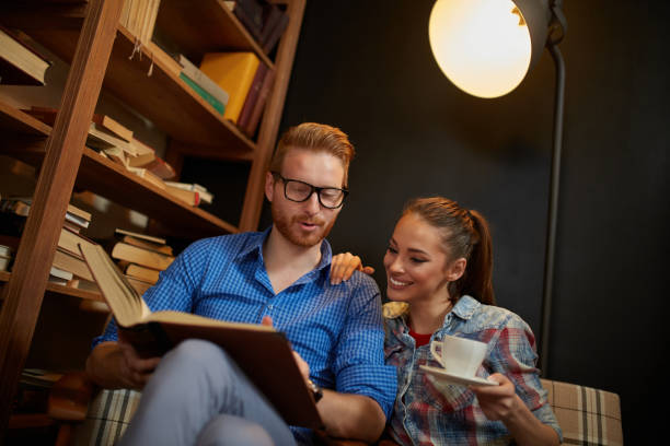 istock Happy young man reading a book to his girlfriend 1347595117