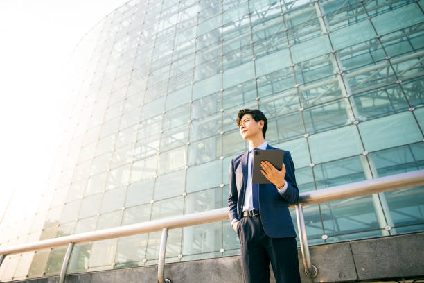 istock Young businessman holding digital tablet and looking away 1347595183