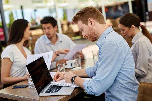 istock Businessman at meeting outdoors using laptop and printed media 1347595184
