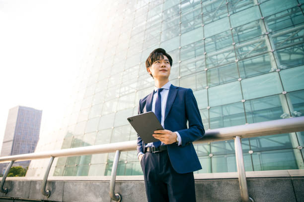 istock Young businessman holding digital tablet and looking away 1347595258