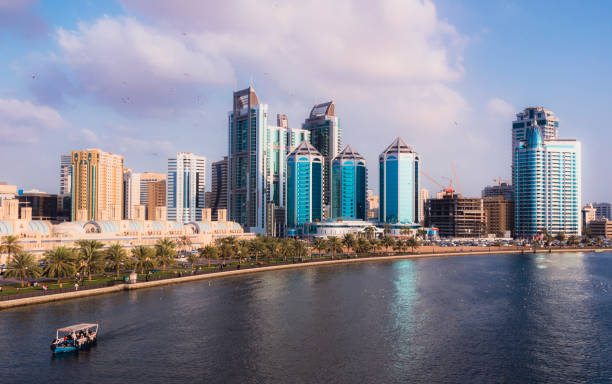 Khalid Lake Waterfront, Sharjah Buildings along Khalid Lake, in downtown Sharjah, UAE, with a water taxi in the background sharjah city stock pictures, royalty-free photos & images