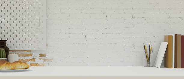 istock Modern workspace with books, stationery and copy space over minimalist white brick wall 1347601444