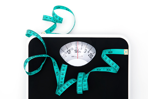 Báscula de peso y cinta métrica sobre fondo blanco con espacio de copia, pérdida de peso o control de dieta saludable para un concepto de cuerpo delgado y saludable photo
