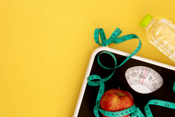 重量スケールと重量を測定するテープ新鮮なリンゴ、減量制御の概念のための健康的な食事 - 低下させる ストックフォトと画像