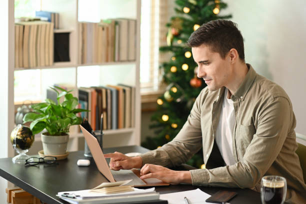 istock Attractive man working online with laptop computer at home office. 1347606821