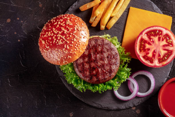 istock Beef burger ingredients, top shot. Hamburger steak, sesame bun, tomato etc 1347610548