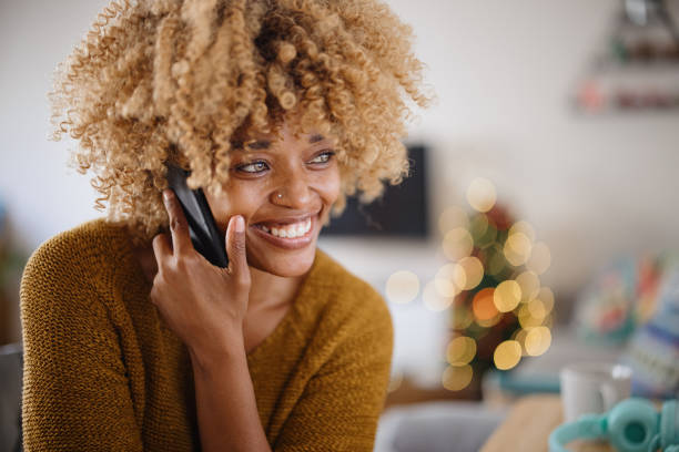 istock Woman using computer and talking on the phone at home during Christmas 1347612382
