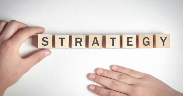 istock Human hand showing Strategy word on wooden cubes. 1347612800