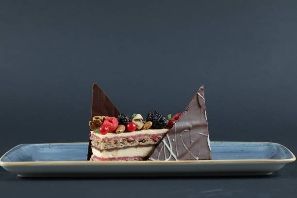 istock Decorated chocolate cake on plate with berries in restaurant isolated on black background 1347612855