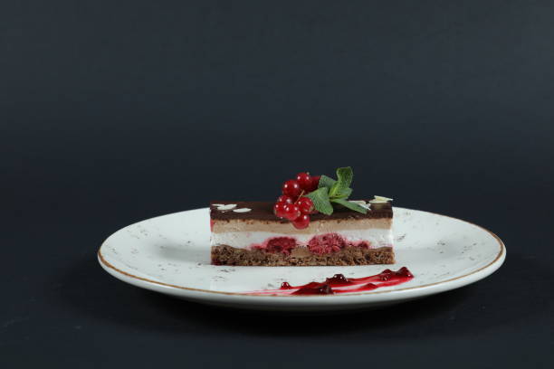 istock Well decorated fruit cake on plate in restaurant isolated on black background 1347612889